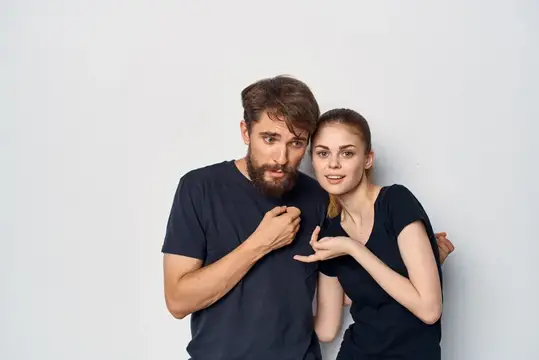 Бородатый мужчина и девушка в чёрных футболках на сером фоне