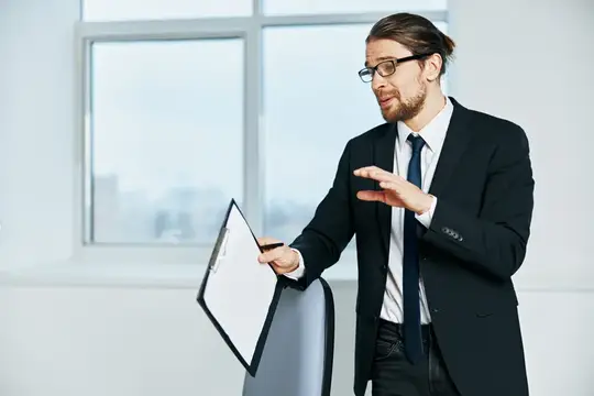 Бизнесмен в костюме работает по телефону в офисе