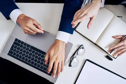 Руки деловых людей за работой на ноутбуке в офисе