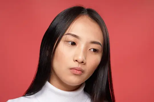 Молодая азиатская женщина с длинными волосами на красном фоне