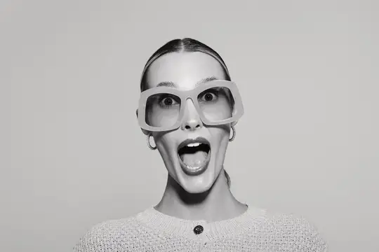 Удивлённая женщина в больших очках с открытым ртом