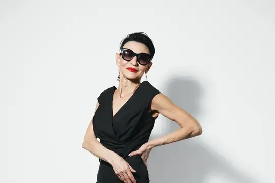 Элегантная женщина в солнцезащитных очках и чёрном платье