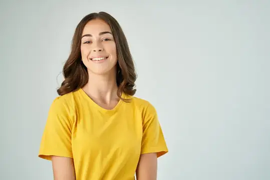 Весёлая женщина с модной прической в жёлтой футболке позирует в стиле life-style