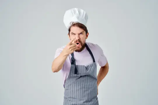 Бородатый повар в колпаке грозит пальцем и кричит