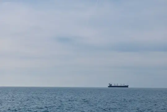 Широкая морская сцена с одиноким судном у горизонта
