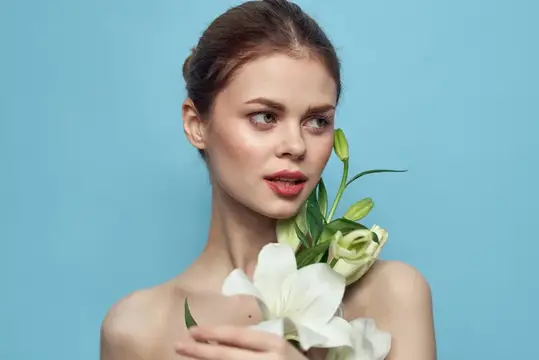 Молодая женщина с белыми лилиями на голубом фоне