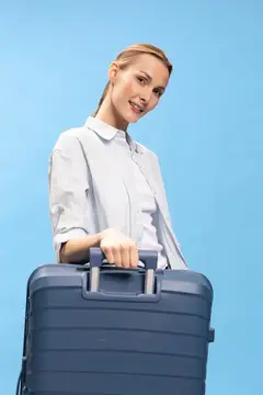Улыбающаяся светловолосая женщина с чемоданом на голубом фоне
