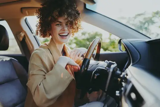 Радостный водитель в уютном салоне автомобиля