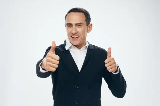Улыбающийся мужчина в пиджаке показывает два больших пальца вверх
