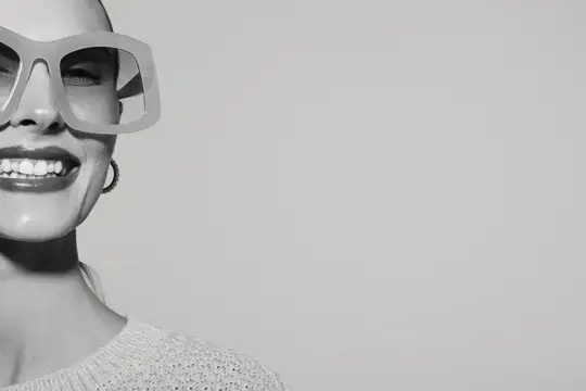 Улыбающаяся женщина в больших солнцезащитных очках, чёрно-белый портрет