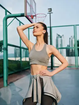 Спортивная девушка отдыхает на баскетбольной площадке после тренировки