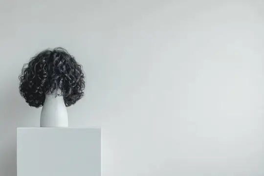 Кудрявый черный парик на белом манекене