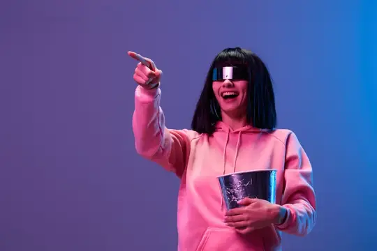Девушка в 3D-очках с попкорном указывает рукой в сторону