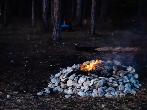 Горящий костёр из камней в тёмном лесу
