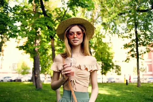 Симпатичная женщина в шляпе гуляет на отдыхе в летнем парке