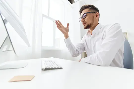 Менеджер работает за компьютером в интернете, излучая официальную уверенность руководителя