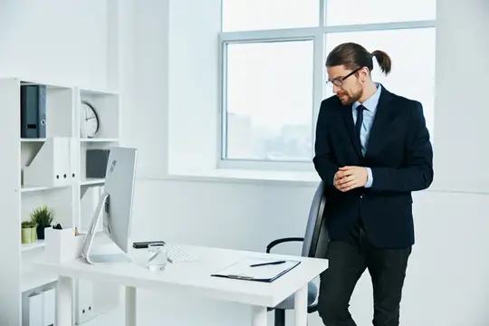 Мужчина в костюме работает с документами, на его лице читаются эмоции