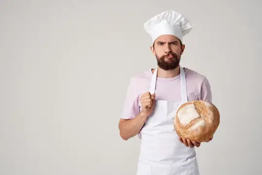 Мужчина в одежде повара, пекарь, работа с мукой и продуктами