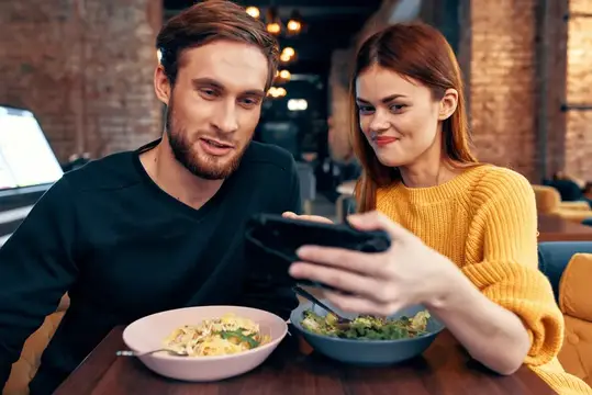 Весёлая молодая пара в ресторане, отдых, развлечения, общение