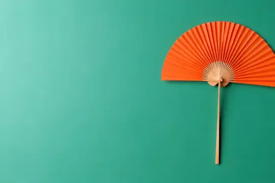 На пышном зеленом фоне представлен потрясающий оранжевый складной веер, сочетающий яркие цвета и текстуру