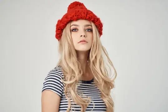 Красивая женщина в модной одежде, красная шляпа, на светлом фоне