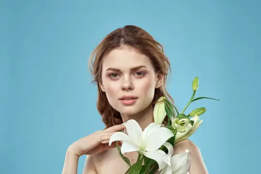 Молодая женщина с белыми лилиями на голубом фоне