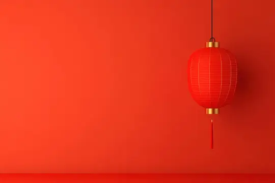 Красный китайский фонарь висит на фоне алой стены