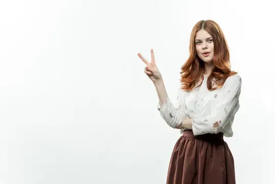 Веселая элегантная женщина жестикулирует рукой в деловом костюме