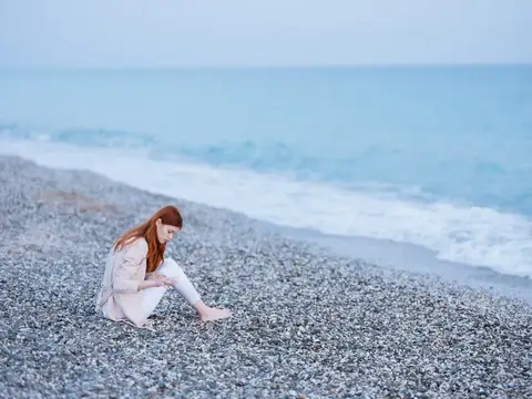Женщина сидит у океана, отдых, свобода, романтика, природа