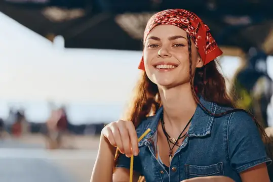 Улыбающаяся девушка в красной бандане и джинсовой рубашке