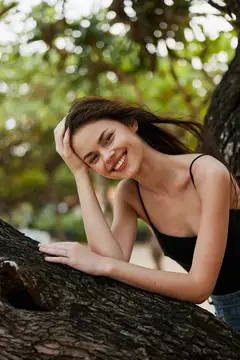 Женщина сидит на холме на закате, расслабляясь и глядя на небо