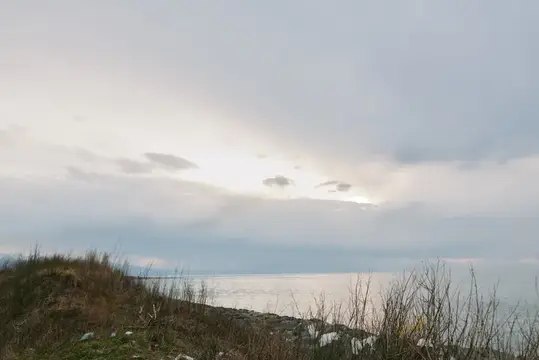 Хмурое небо над пустынным каменистым берегом и морем