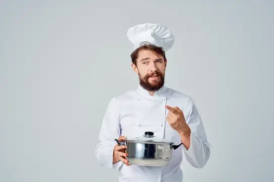 Весёлый мужчина-шеф-повар на кухне, работающий в кулинарной индустрии