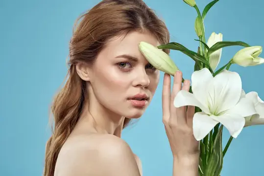 Рыжеволосая девушка с белыми лилиями на голубом фоне