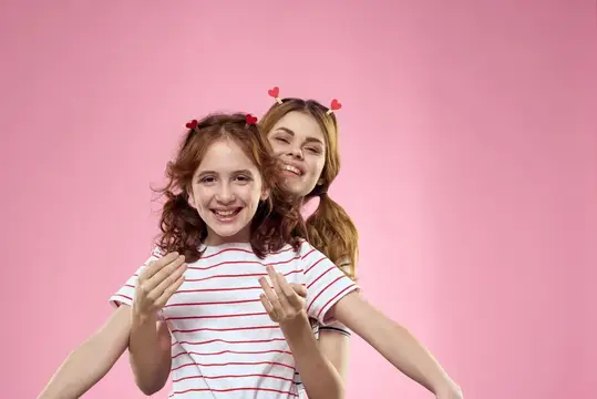 Рыжеволосая девочка и девушка с сердечками на розовом фоне