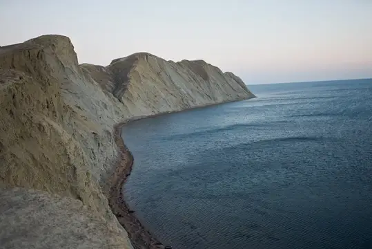 Изрезанный скалистый берег и спокойное море на закате