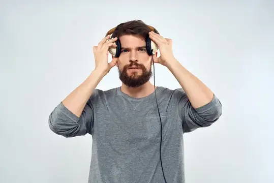 Мужчина-фотограф с профессиональной камерой работает в студии