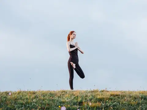 Спортивная женщина выполняет гимнастические упражнения на природе в горах