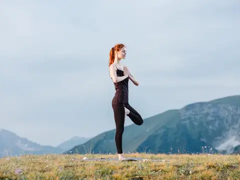 Спортивная женщина занимается гимнастикой на природе в горах
