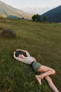 На ней бежевый свитер и шорты