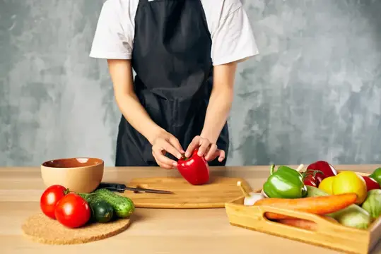 Женщина-повар на кухне нарезает овощи для салата, диетическое питание