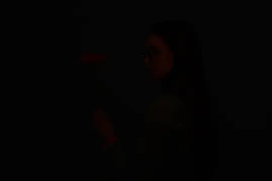 Тёмный силуэт девушки в профиль на чёрном фоне