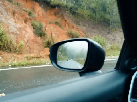 Вид из салона автомобиля на дорогу и глинистый склон