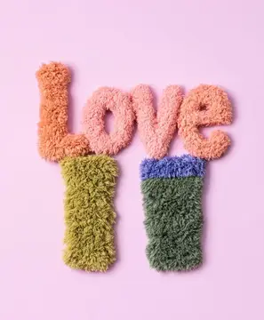 Пушистая надпись Love и две пары вязаных носков на розовом фоне