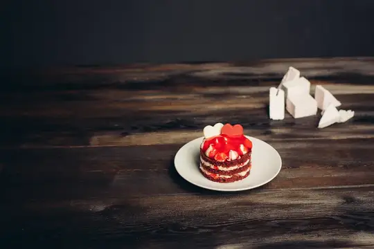 Маленький торт с клубникой и сердечком на тёмном деревянном столе