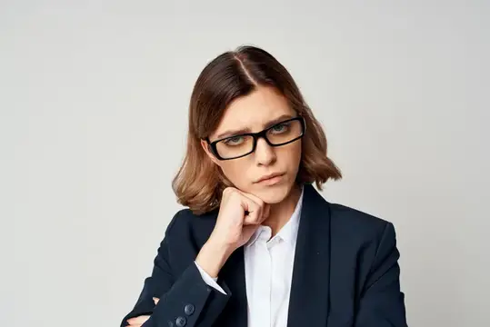 Задумчивая женщина в очках и деловом костюме