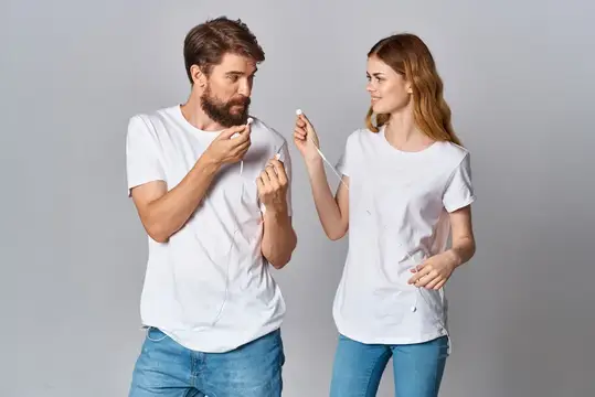 Мужчина и женщина в белых футболках держат ватные палочки
