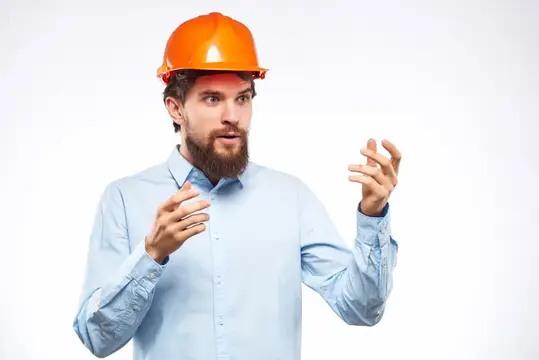 Бородатый мужчина работает в строительной отрасли в защитной униформе