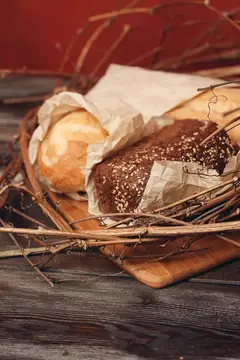 Выпечка буханки хлеба, мука, продукт в форме гнезда на деревянном столе