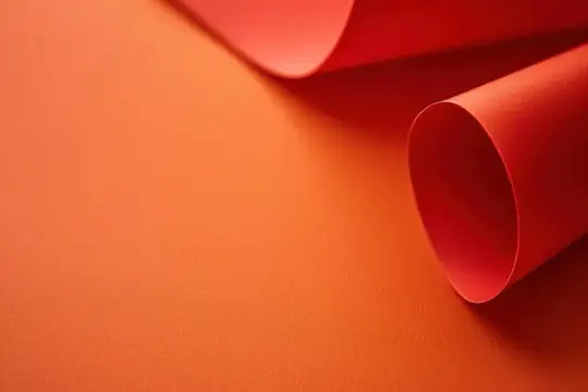 Скрученные листы красной бумаги на оранжевом фоне